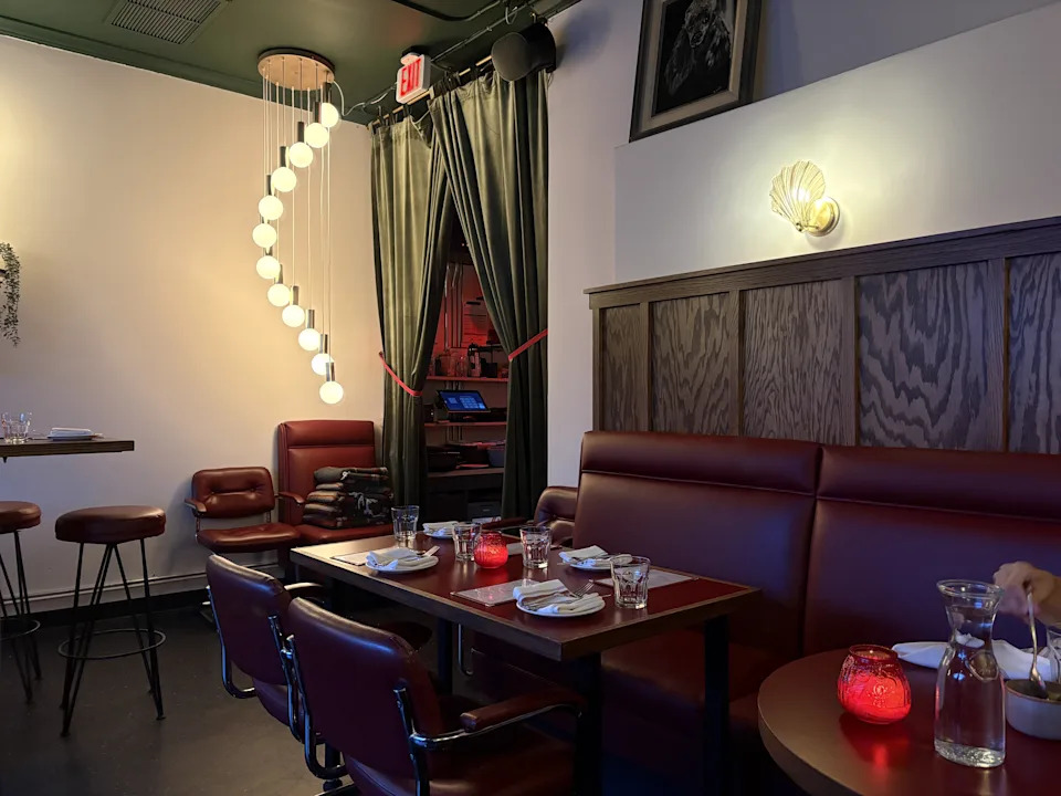 Red booths and a dining room with string lamps at Bess in Sierra Madre.