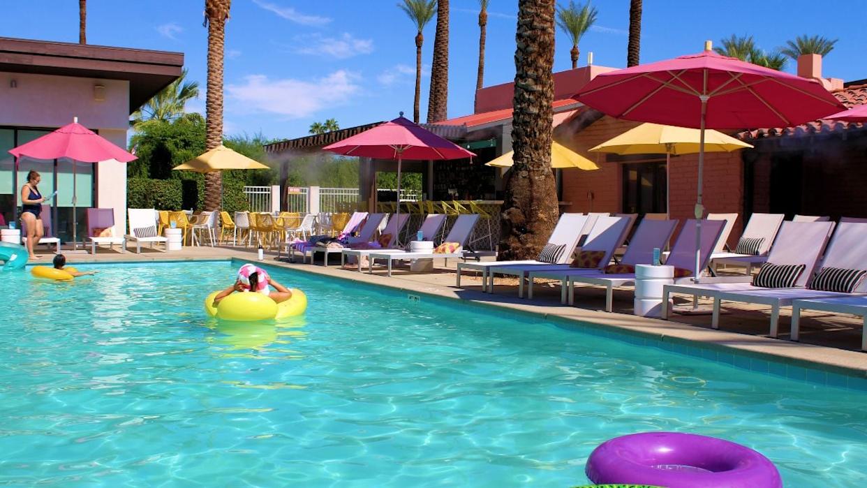 A spacious outdoor pool with lounge chairs and palm trees at a relaxed, family-friendly hotel near Disneyland