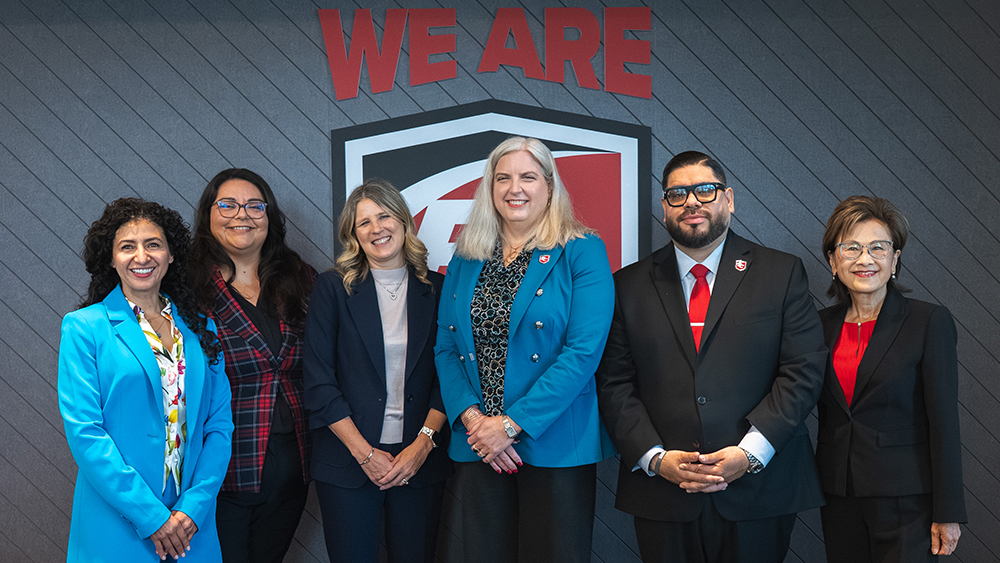 5 adults standing in front of a Bakersfield College logo