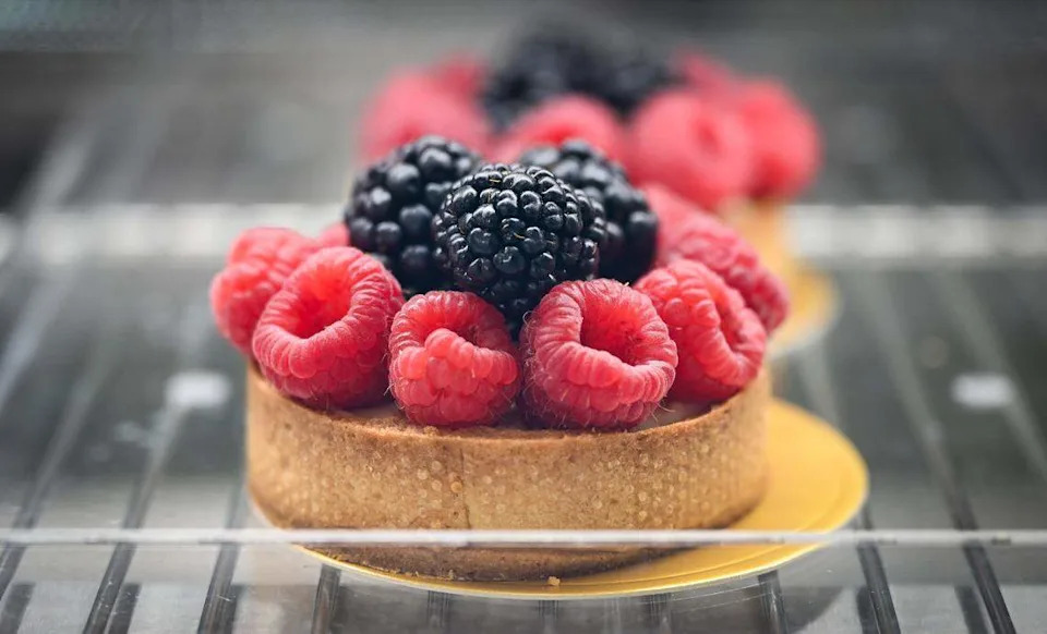 A fruit tart is displayed with various treats and baked goods in the cabinet at Lodéi Bakery & Cafe, an Armenian family-owned bakery on the northeast corner of Palm and Bullard avenues.