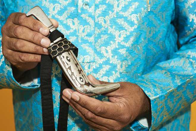 A close up of a Sikh man holding his Kirpan A photo of a Kirpan