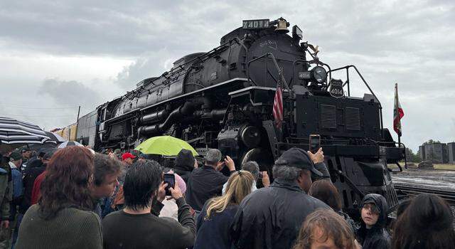 Union Pacific Railroad’s Big Boy No. 4014 sits the tracks along Atlantic Street in Roseville’s historic district on Friday, April 10, 2026, as a crowd gathers with umbrellas under cloudy skies. The locomotive’s stop in Roseville included free public tours and community activities downtown.