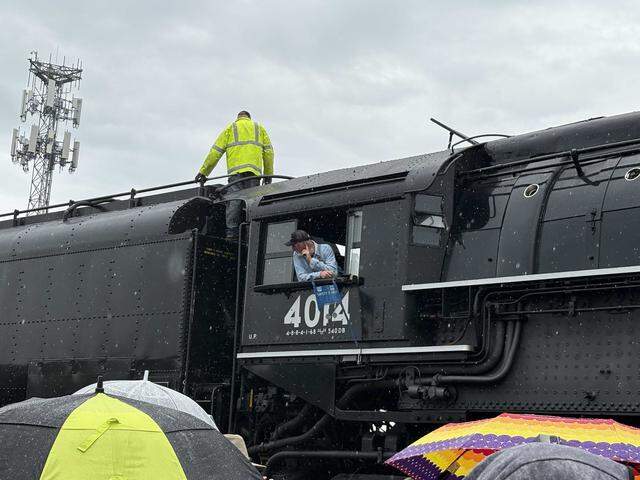 A crew member looks out from the cab of Union Pacific Railroad’s Big Boy No. 4014 as another worker stands atop the hulking steam locomotive along Atlantic Street in Roseville’s historic district on Friday, April 10, 2026. After its Roseville stop, the train is scheduled to continue to Colfax and Truckee before heading east into Nevada.
