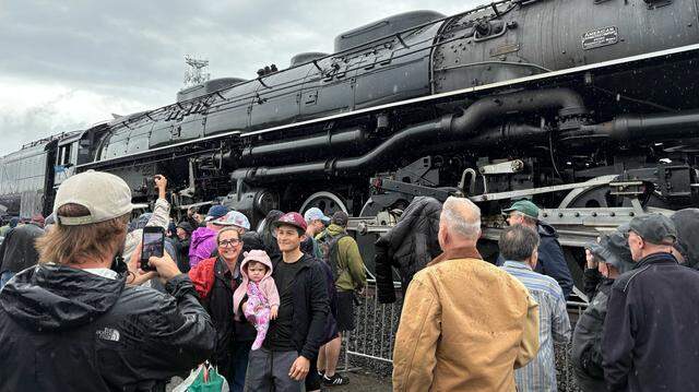 Visitors pose for photos in front of Union Pacific Railroad’s Big Boy No. 4014 along Atlantic Street in Roseville’s historic district on Friday, April 10, 2026. The restored steam locomotive is traveling across the country to commemorate the nation’s 250th anniversary.