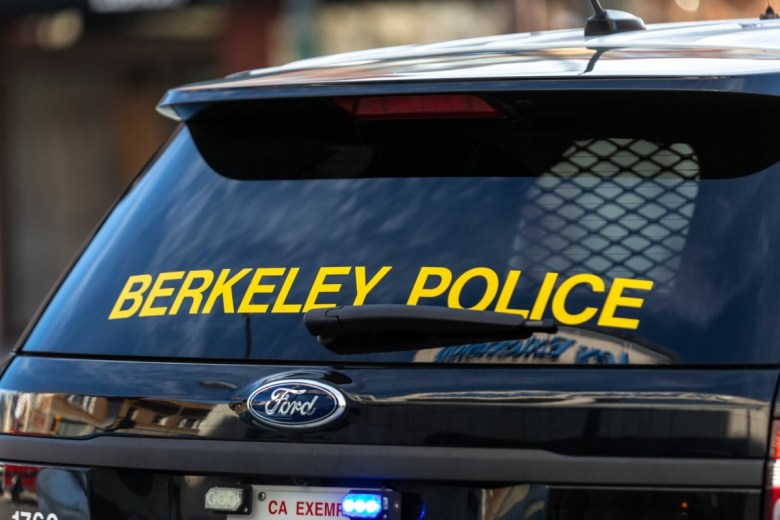 The rear of a Berkeley Police Department cruiser displays the name of the agency on the rear windshield.