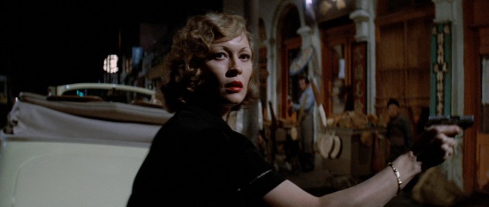 a blond woman holding a gun