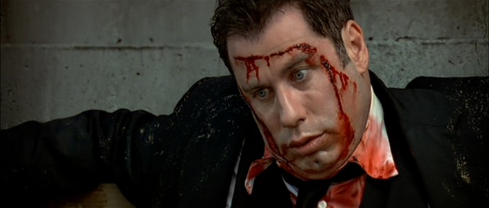 a man is slouched over with blood running down his face