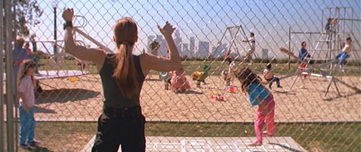 a woman watches a children's playground