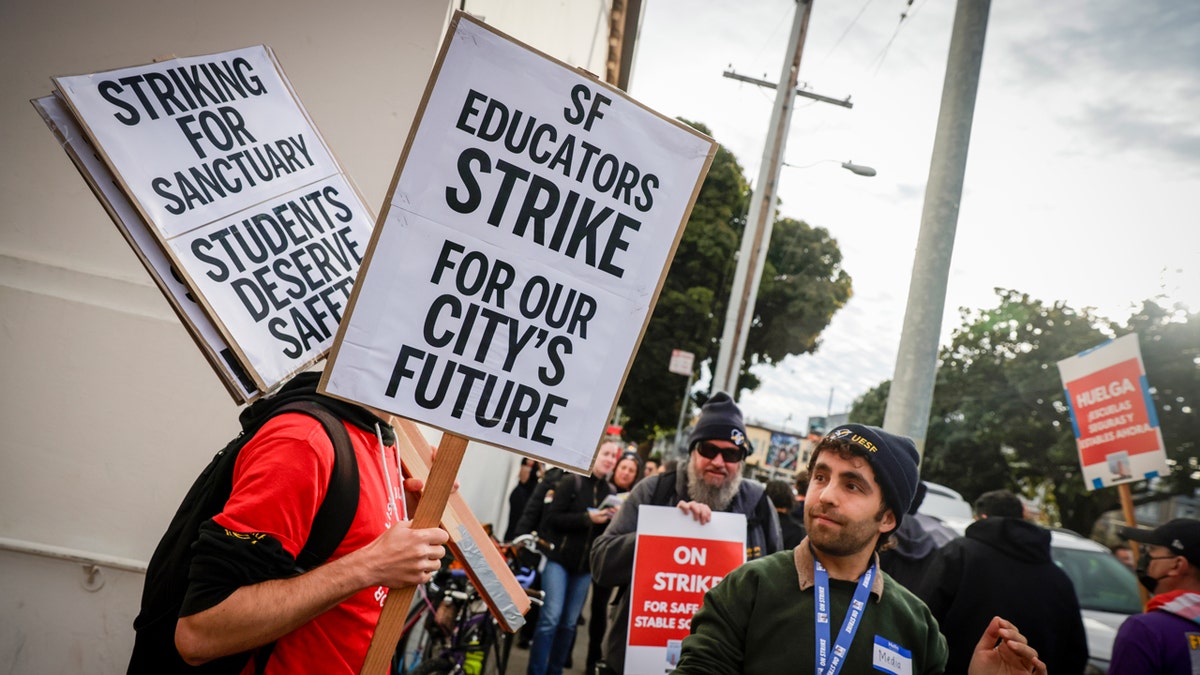 People carry signs during a teachers strike