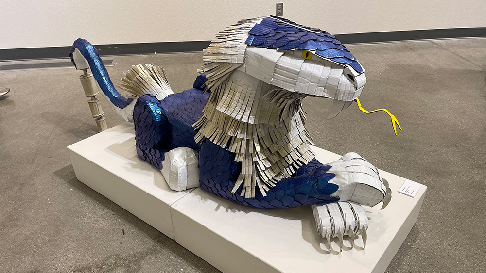 large dragaon shaped art piece made of cardboard