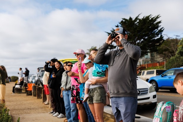 People gather at Sunset Cliffs to try to get a view of the Artemis II splashdown on Friday, April 10, 2026. (Kristian Carreon / The San Diego Union-Tribune)