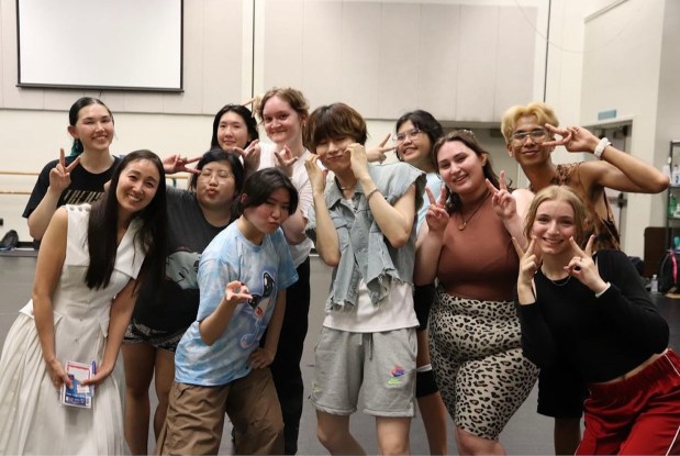 Students gather after a K-pop idol master class organized by Chuyun Oh, front left, at Fresno State in 2023. The students are posing with K-pop idol and E'LAST member Won Hyuk, center, in denim cutoff jacket. (Chuyun Oh)