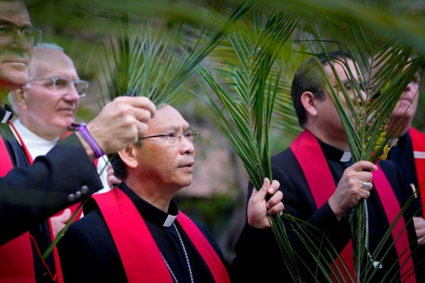 Bishop Michael Pham (middle) and Auxiliary Bishop Felipe Pulidoamong (right) with the Roman Catholic Diocese of San Diego were among the peaceful demonstrators carrying palm branches outside the Federal Courthouse building in downtown San Diego on Wednesday, April 1, 2026. The daily demonstration is to show support for migrants arriving for immigration court.  (Nelvin C. Cepeda / The San Diego Union-Tribune)