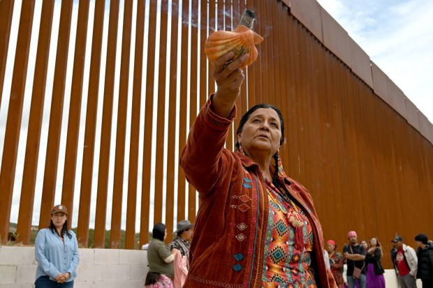 Norma Alicia Mesa Calles, a member of native communities, mainly Kumeyaay native group, blessed people during a "ceremony" rally against the destruction of the Kuchamaa Mountain left by the construction of a new border wall at the US-Mexico Border in Tecate, Baja California, Mexico on Sunday, April 12, 2026. The Kuchamaa Mountain is considered a sacred site by native groups living in both sides of the border. (Carlos Moreno / The San Diego Union-Tribune)