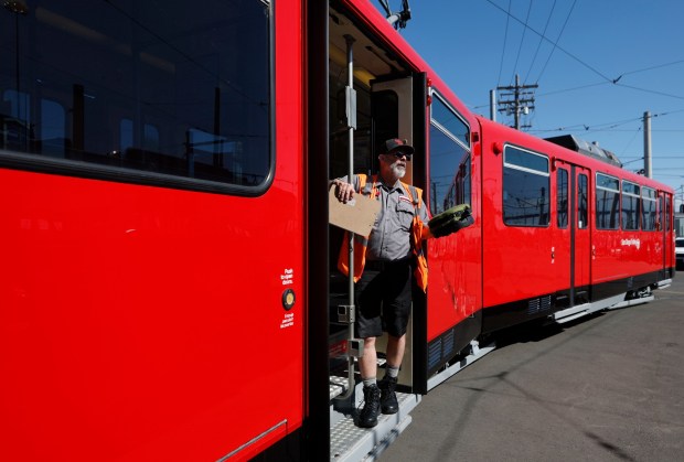 Operator Giff Haug stands in the very first iconic red San Diego Trolley, the 1001, part of the Silver Line's vintage vehicles fleet, on March 9, 2026 in San Diego. (K.C. Alfred / The San Diego Union-Tribune)