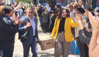two people carrying a box between two lines of people