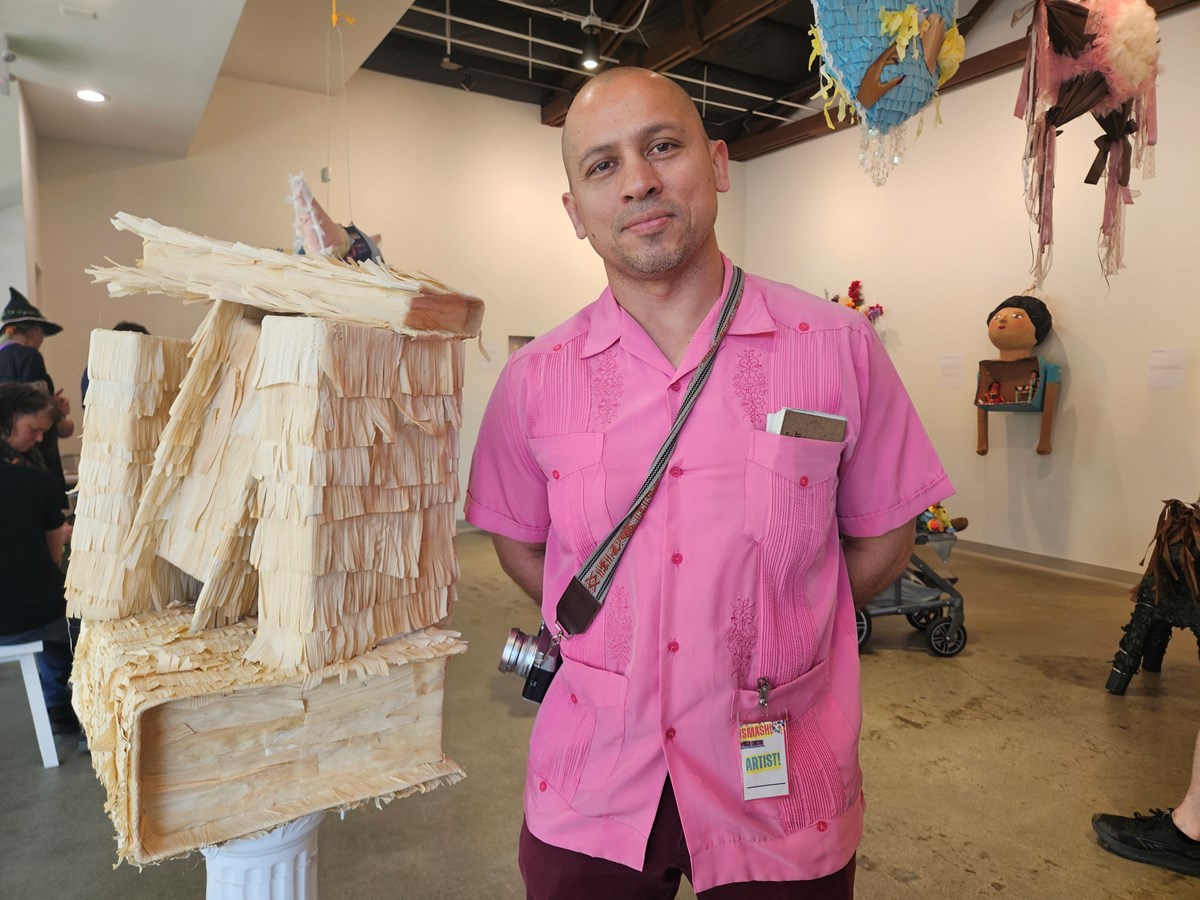 Andres Alvarez’s piñata is titled “In ixtli, in yollotl” (the face, the heart.) It features a stack of books, representing works by Latino and Chicano authors, wrapped in hojas de maiz (corn husks) as a symbol of culture.