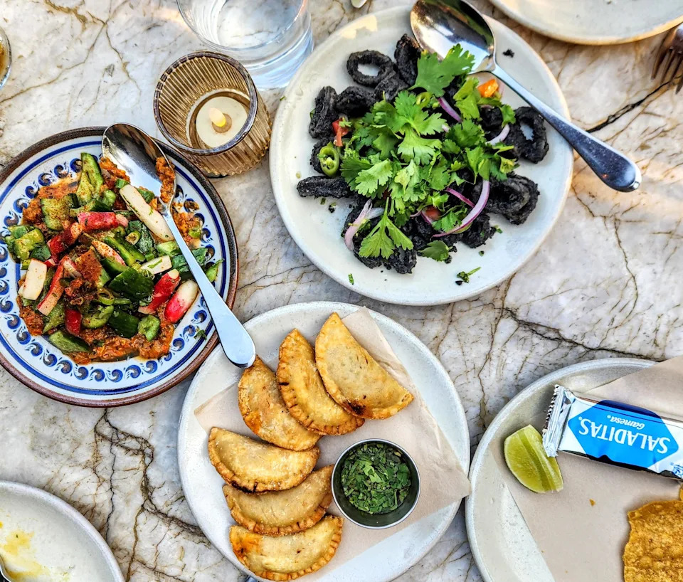 A spread of dishes from Dama including empanadas and squid.