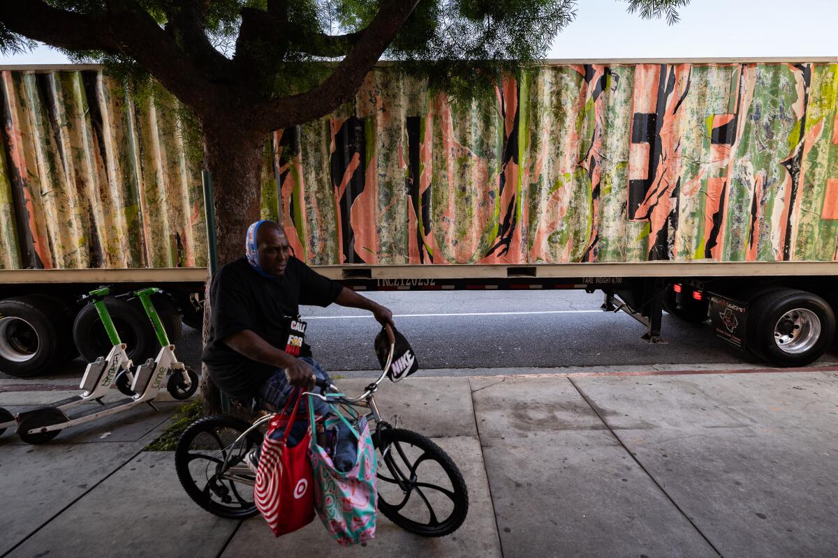 A man riding a bike passes by LA-based artist Edgar Ramirez's art piece entitled "I want to be free" 
