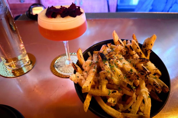 A Pretty Please cocktail and truffle cheese fries from Confessional 1902 on April, 25 2026. (Photo by Mercedes Cannon-Tran/SCNG)