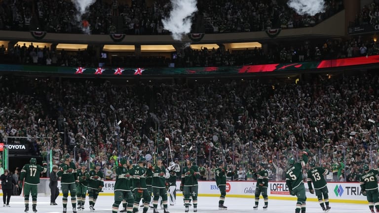 Minnesota Wild players celebrate after wining Game 6 in the...
