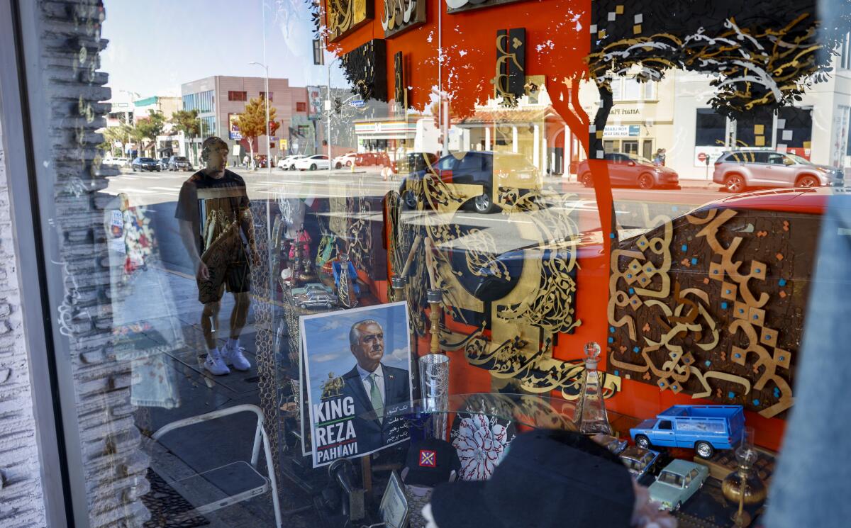 A pedestrian reflected in the Gallery Eshgh store window.