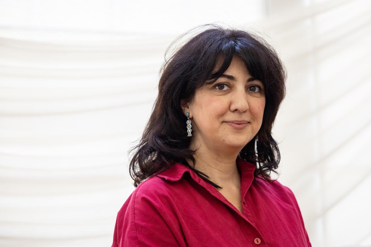 A woman with dark hair, in a red shirt