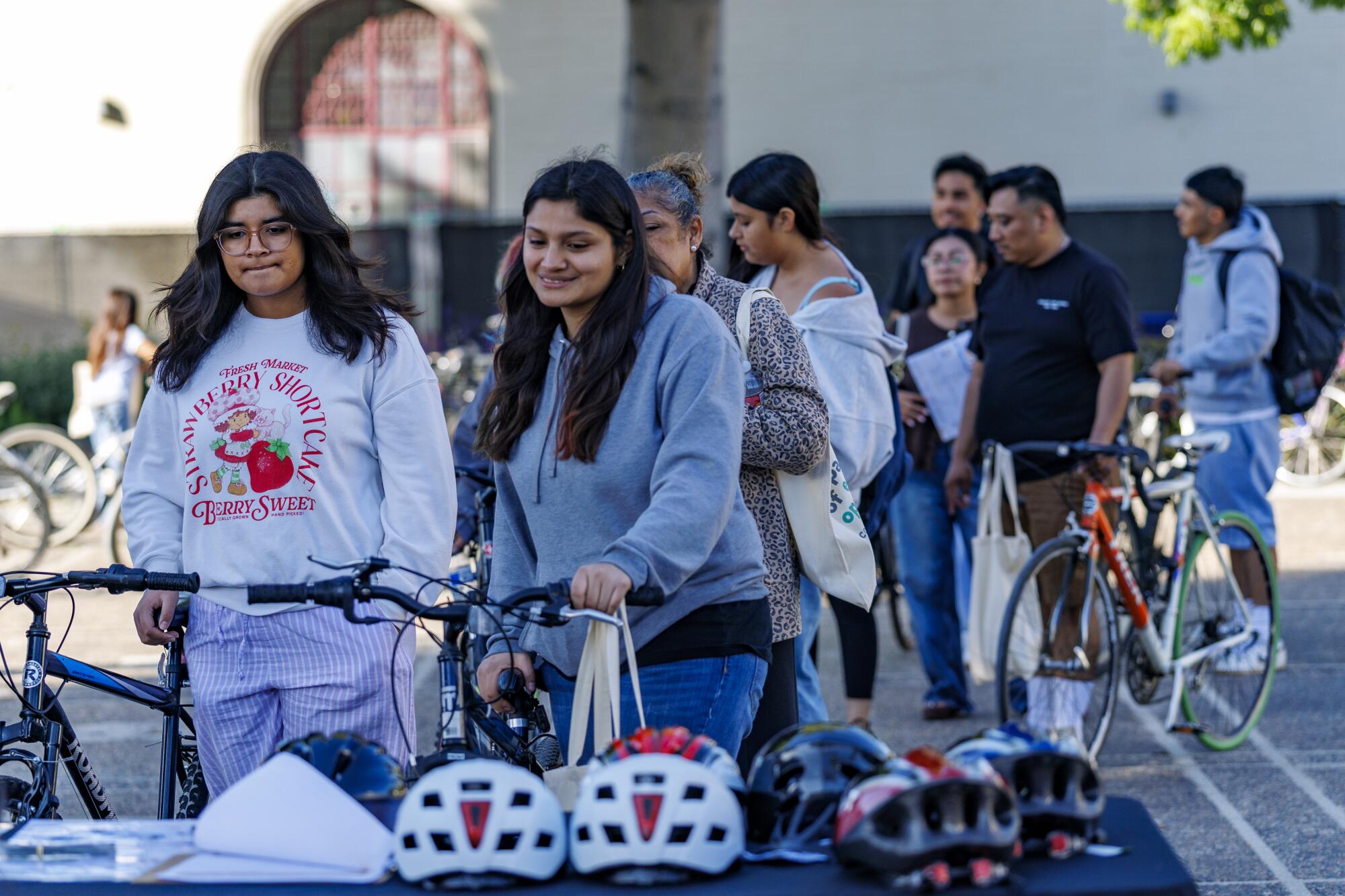 People wait in line to get a free helmet after choosing a bike during a bike give-away event