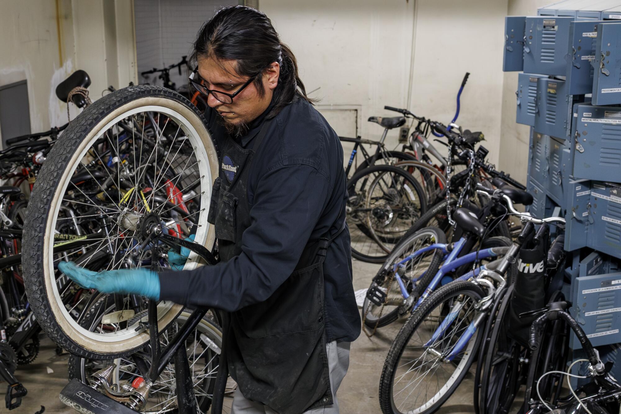 Olin Reyes repairs abandoned bikes in a dusty basement of the shuttered General Hospital in Los Angeles.