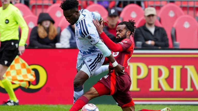 Toronto FC defender Raheem Edwards, right, tackles San Jose Earthquakes...
