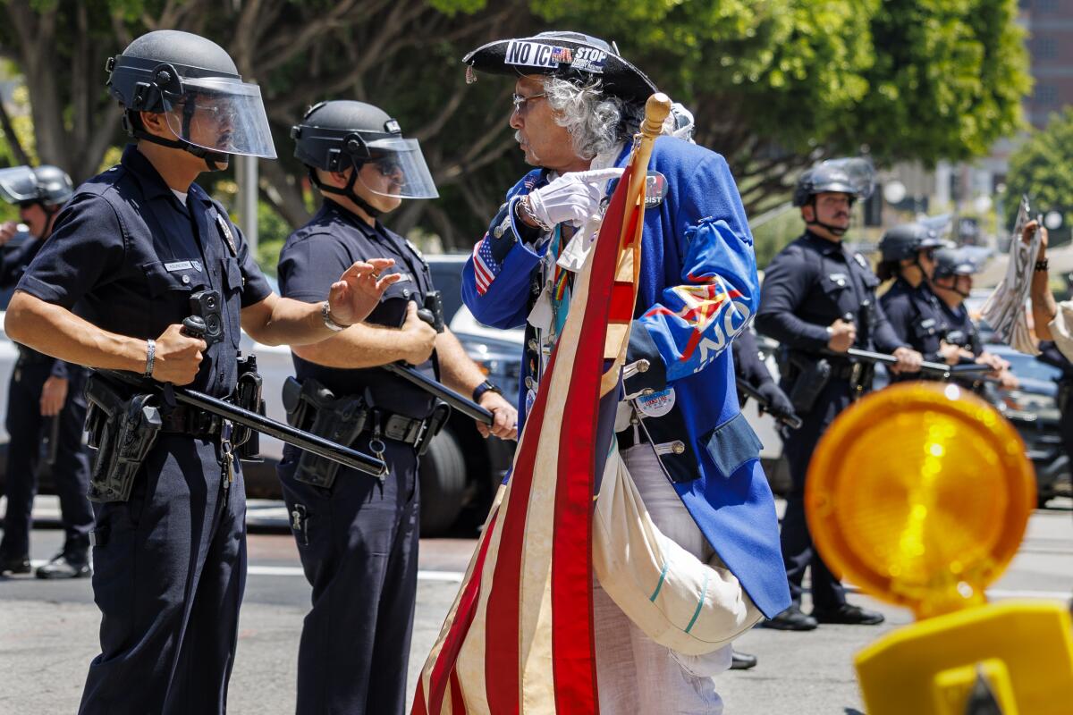A man dressed in 1776 attire confronts Los Angeles police officers.