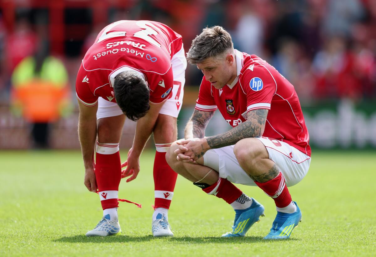 Wrexham's Josh Windass squats on the field and looks dejected following a draw with Middlesbrough.