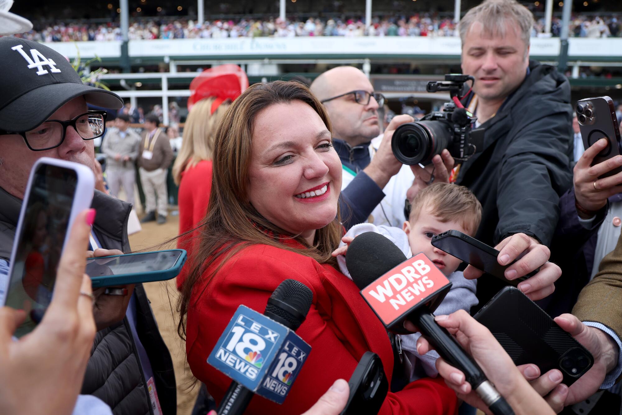 Cherie DeVaux celebrates with family after becoming the first female trainer to win the Kentucky Derby.