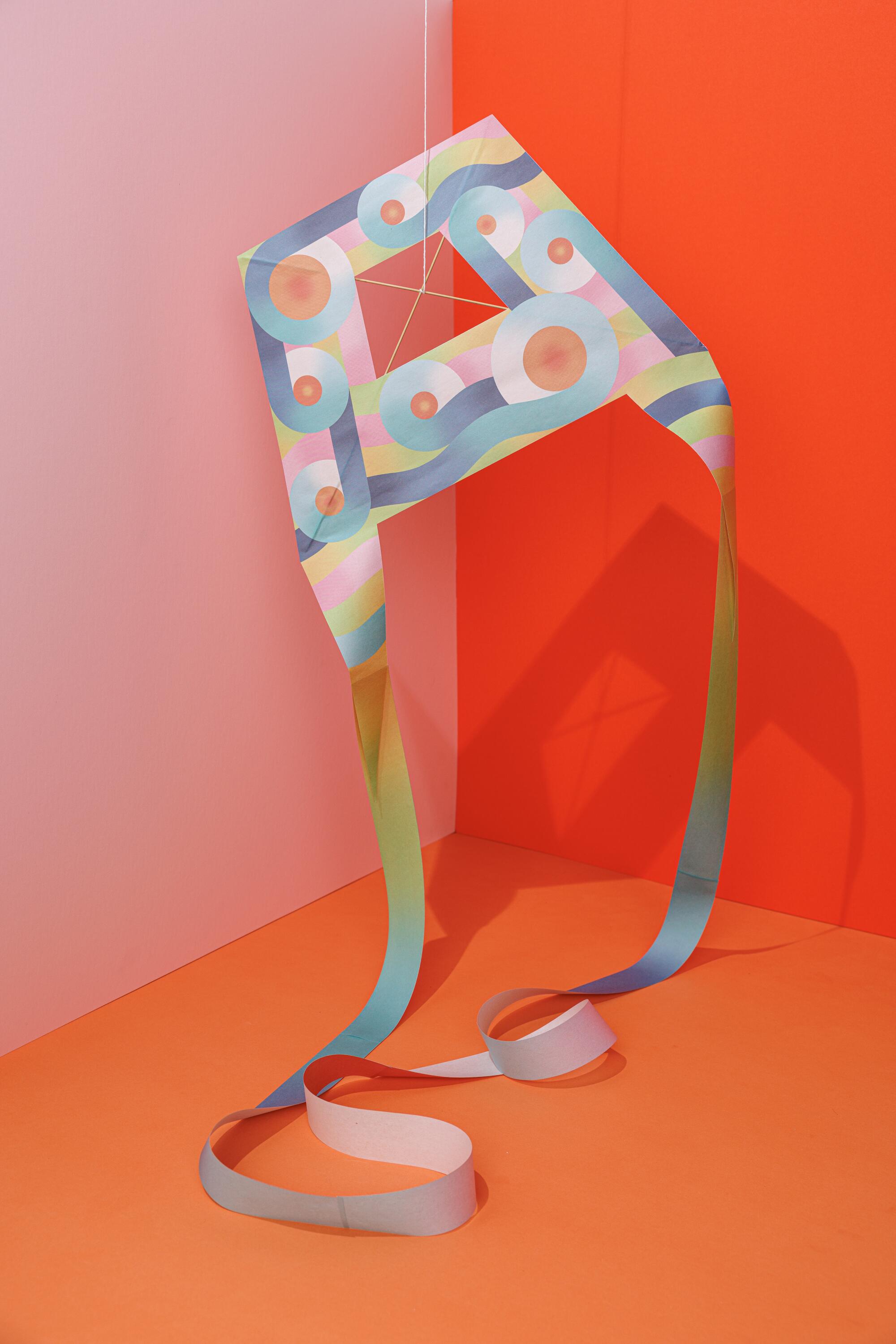 A paper kite in front of a colorful background 