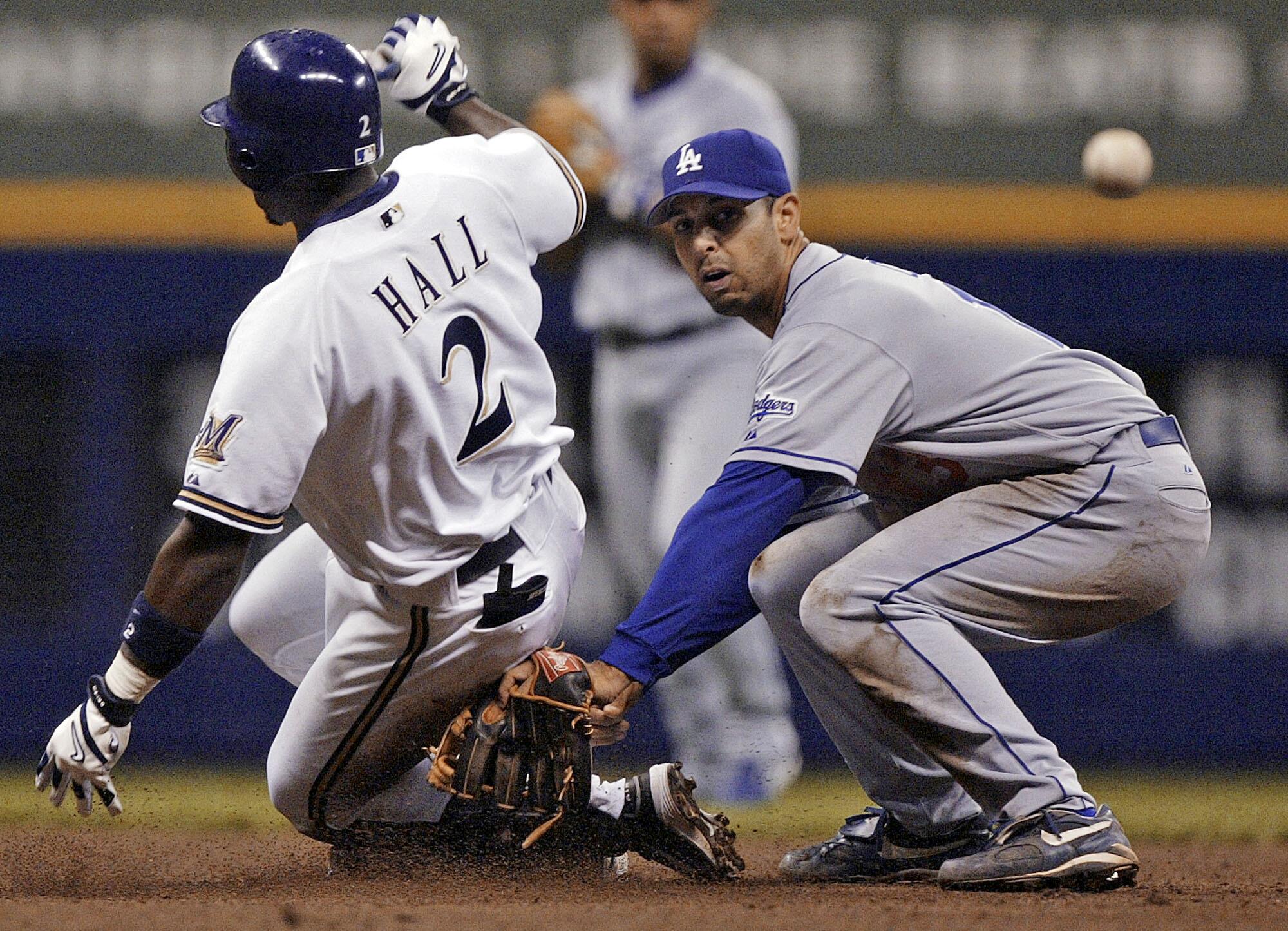 Alex Cora wearing a Dodgers uniform and crouching on the field with his glove on