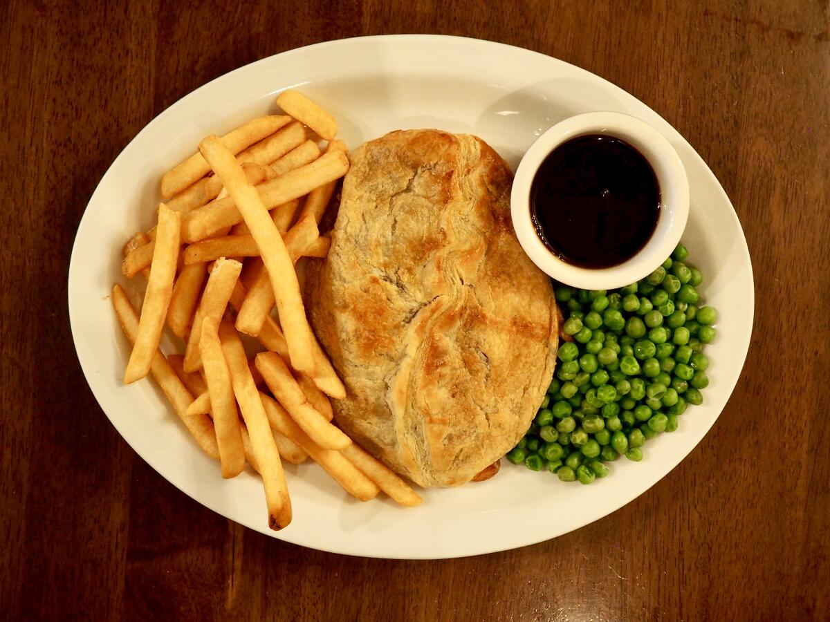 A Cornish pasty from Robin Hood British Pub in Sherman Oaks with a side of chips, peas and gravy.