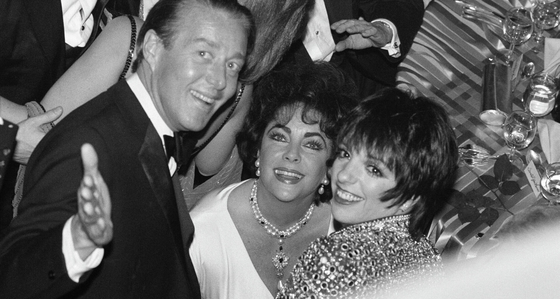 New York, New York, USA - May 7, 1981: Fashion designer, Halston, actress Elizabeth Taylor and singer and actress Liza Minnelli smile at the opening night party for the Broadway revival of the play 'The Little Foxes.'