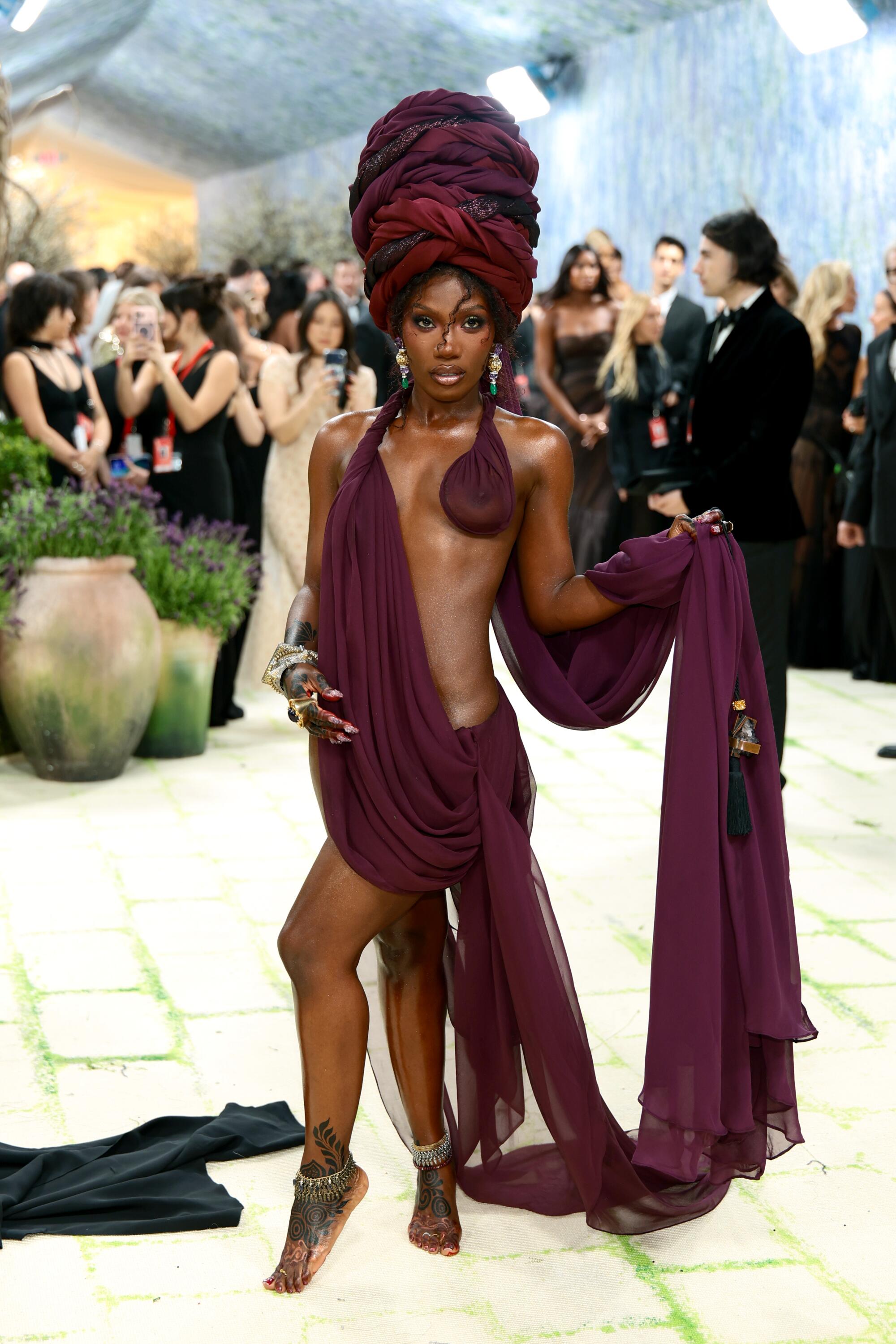 Doechii is draped in burgundy fabric. 