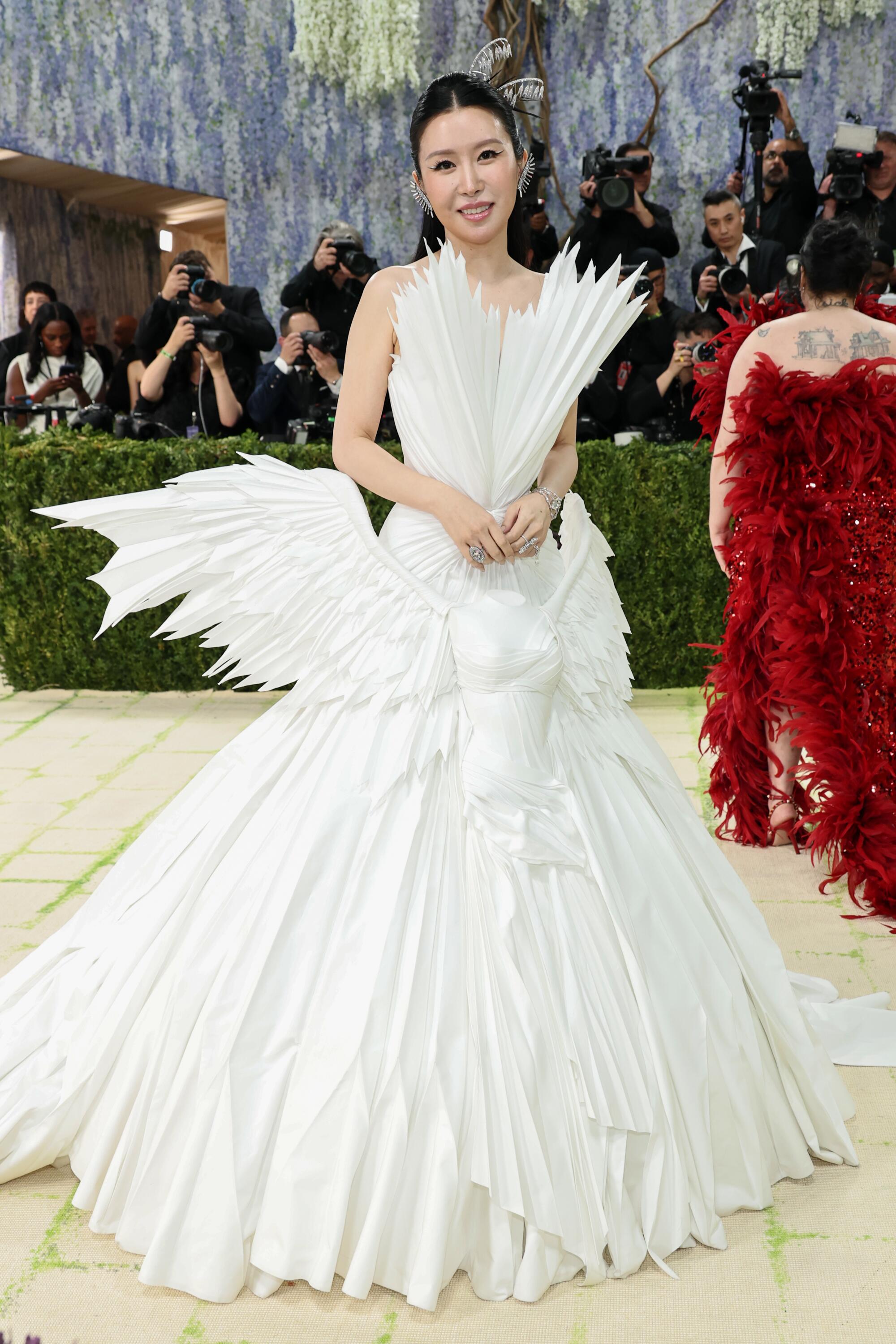 Yu-Chi Lyra Kuo, wearing a white gown, poses at the Met Gala. 