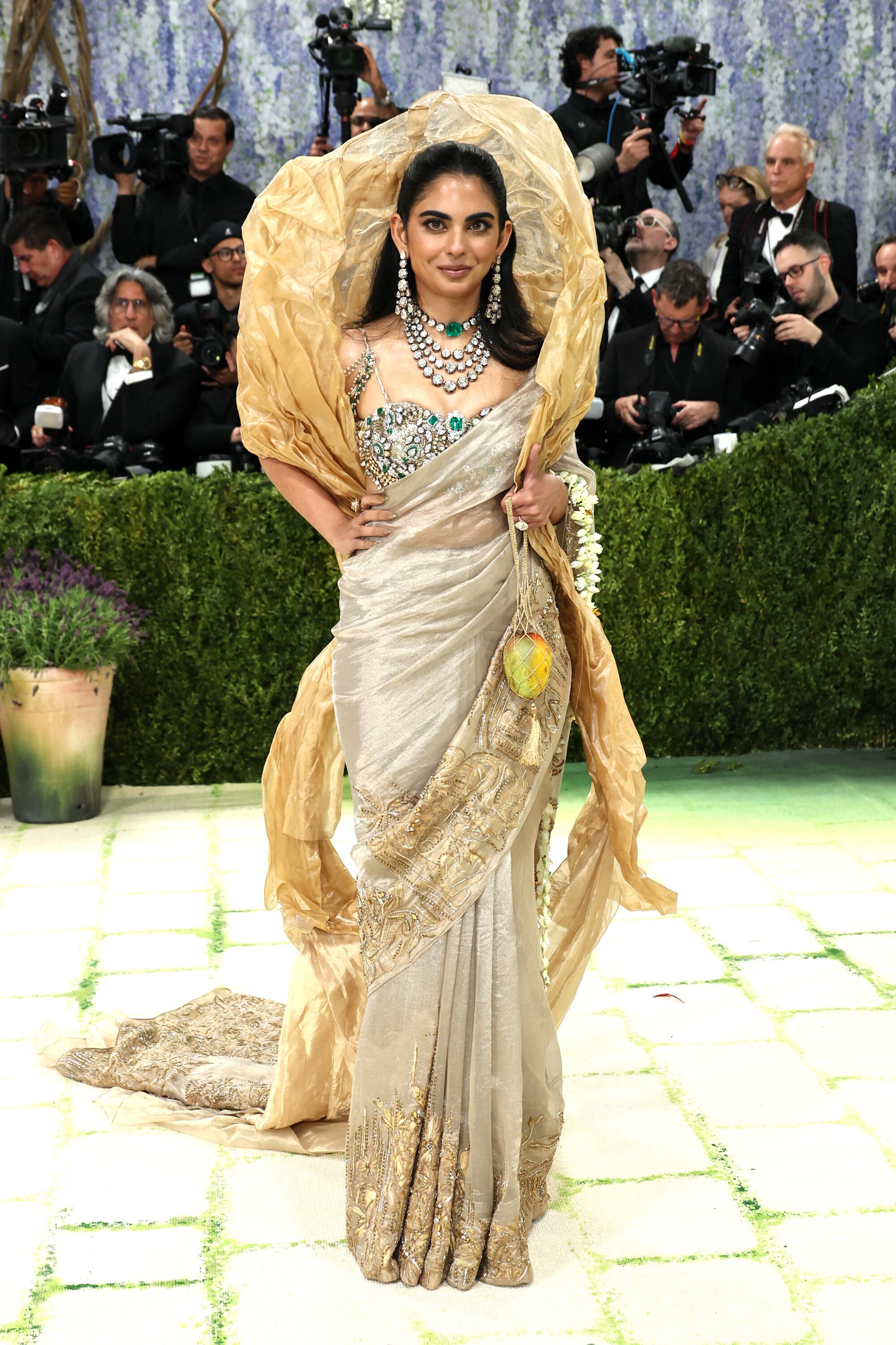 Isha Ambani, wearing a gold saree, poses at the Met Gala.