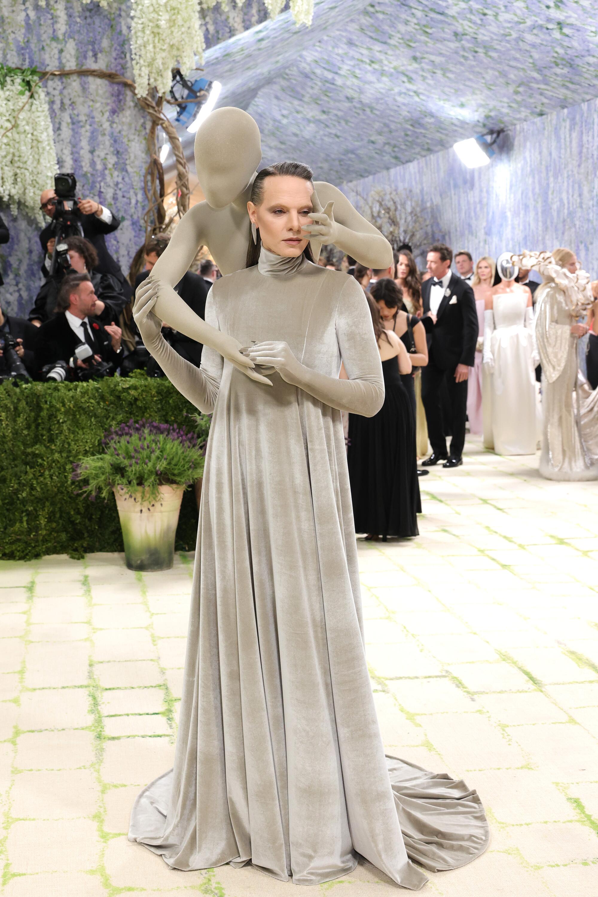 Jordan Roth walks with a sculpture on his back.