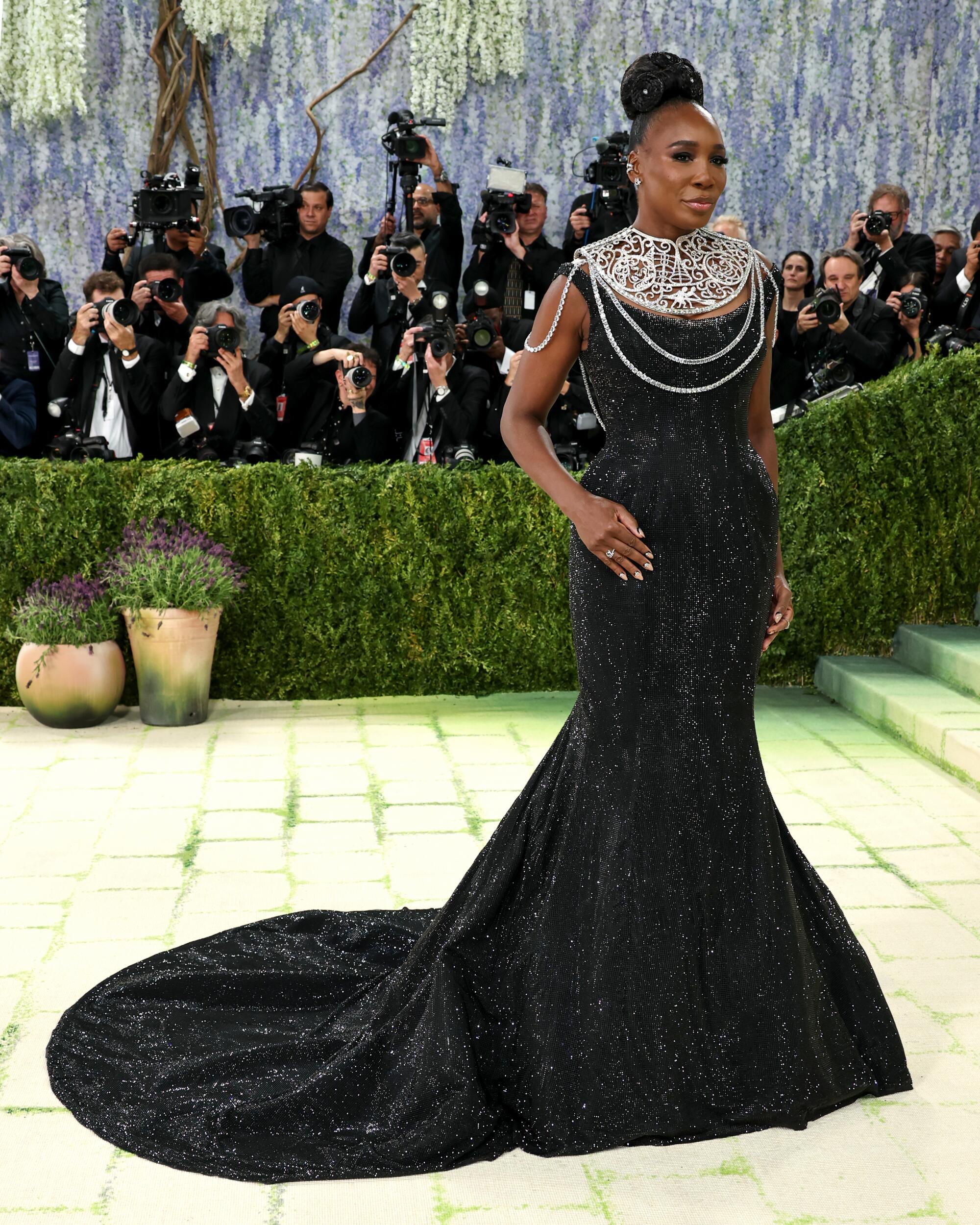 Venus Williams, wearing a black gown, poses at the Met Gala.