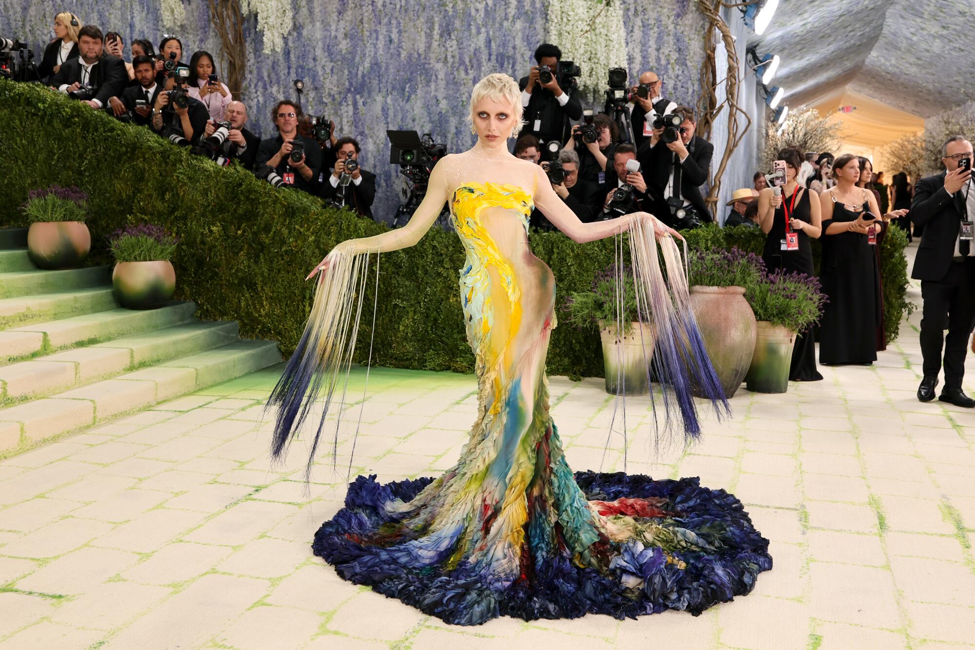 Emma Chamberlain, wearing a colorful gown, poses at the Met Gala. 