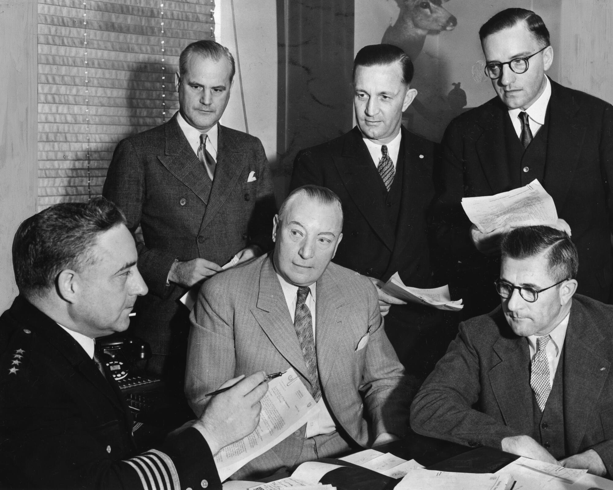 a black and white photo of police officials meeting in 1936