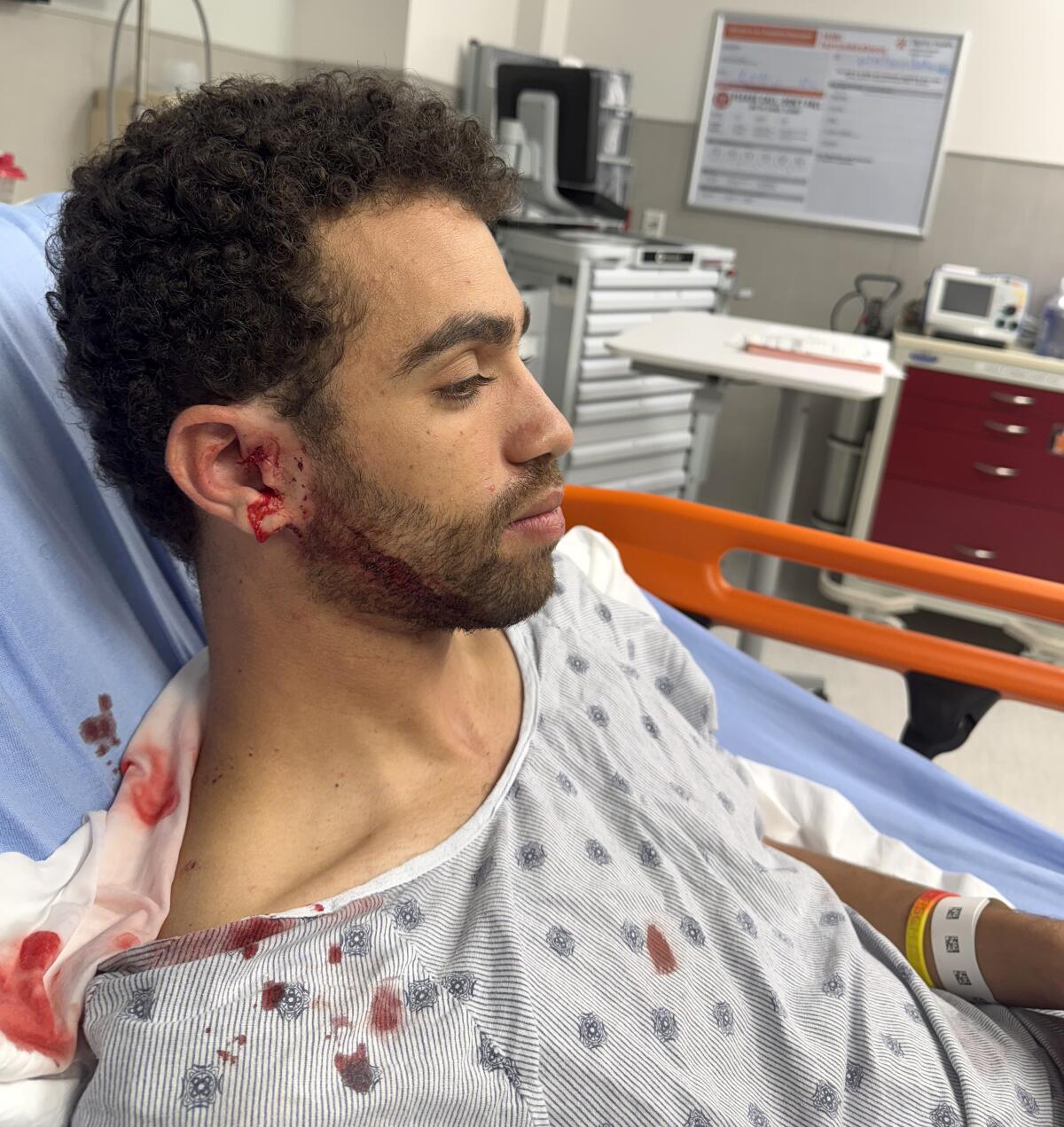 Micah Moore in a hospital bed with a bloody ear