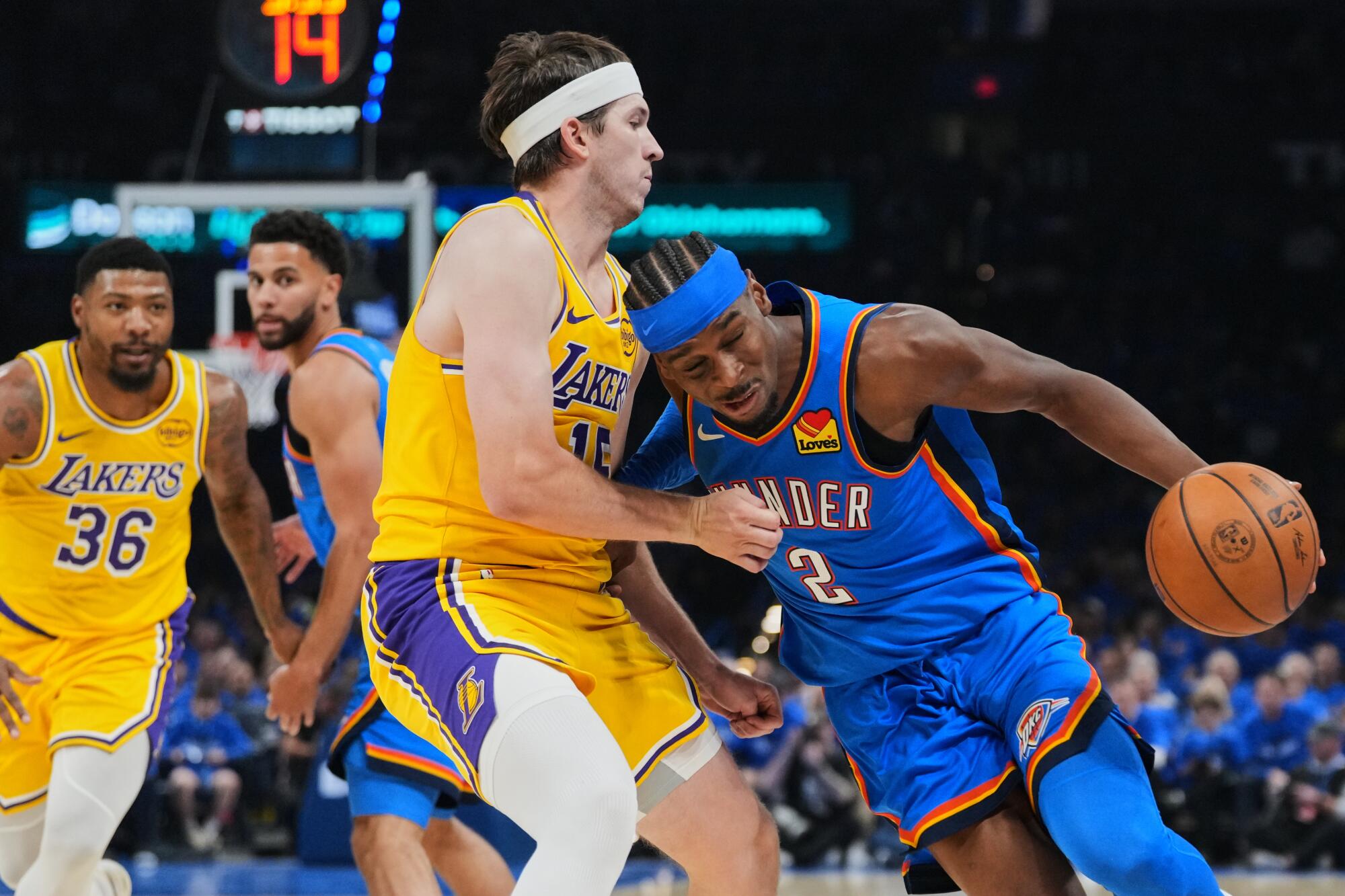 Thunder guard Shai Gilgeous-Alexander, right, puts his right shoulder into Lakers guard Austin Reaves, left, as he drives.