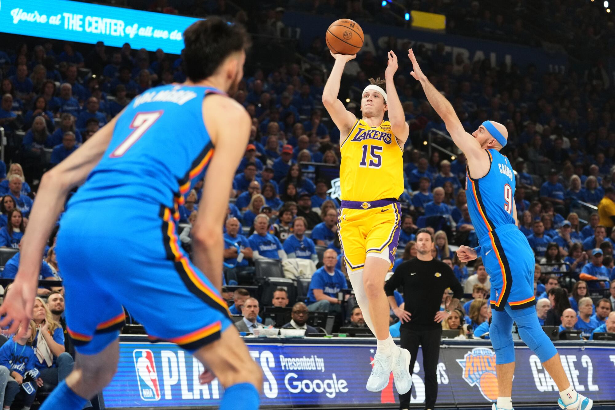 Lakers guard Austin Reaves, center, takes a shot in the lane over Thunder center Chet Holmgren, left, and Alex Caruso.