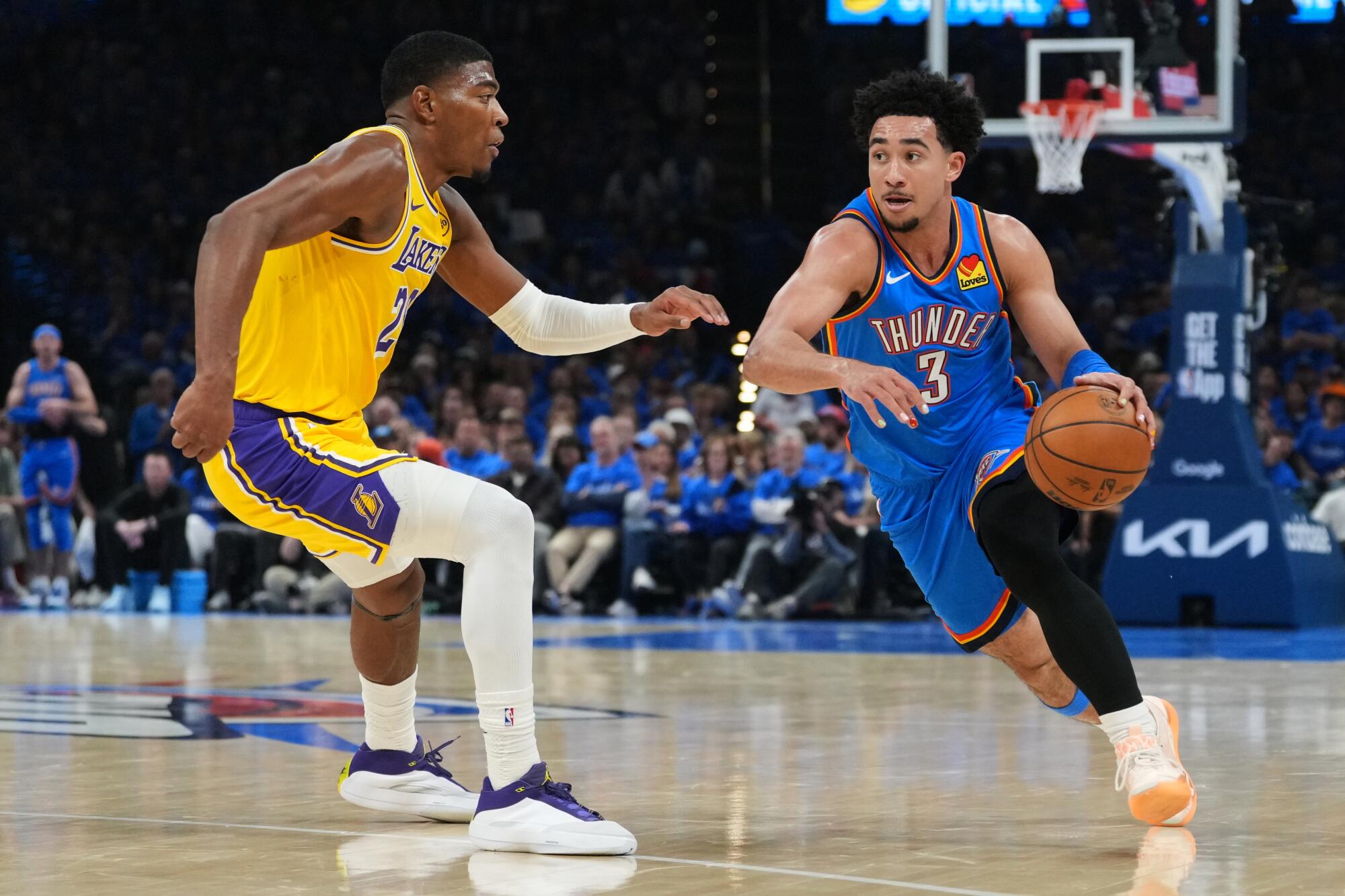 Thunder guard Jared McCain, right, drives to the basket against Lakers forward Rui Hachimura, left, during Game 1.