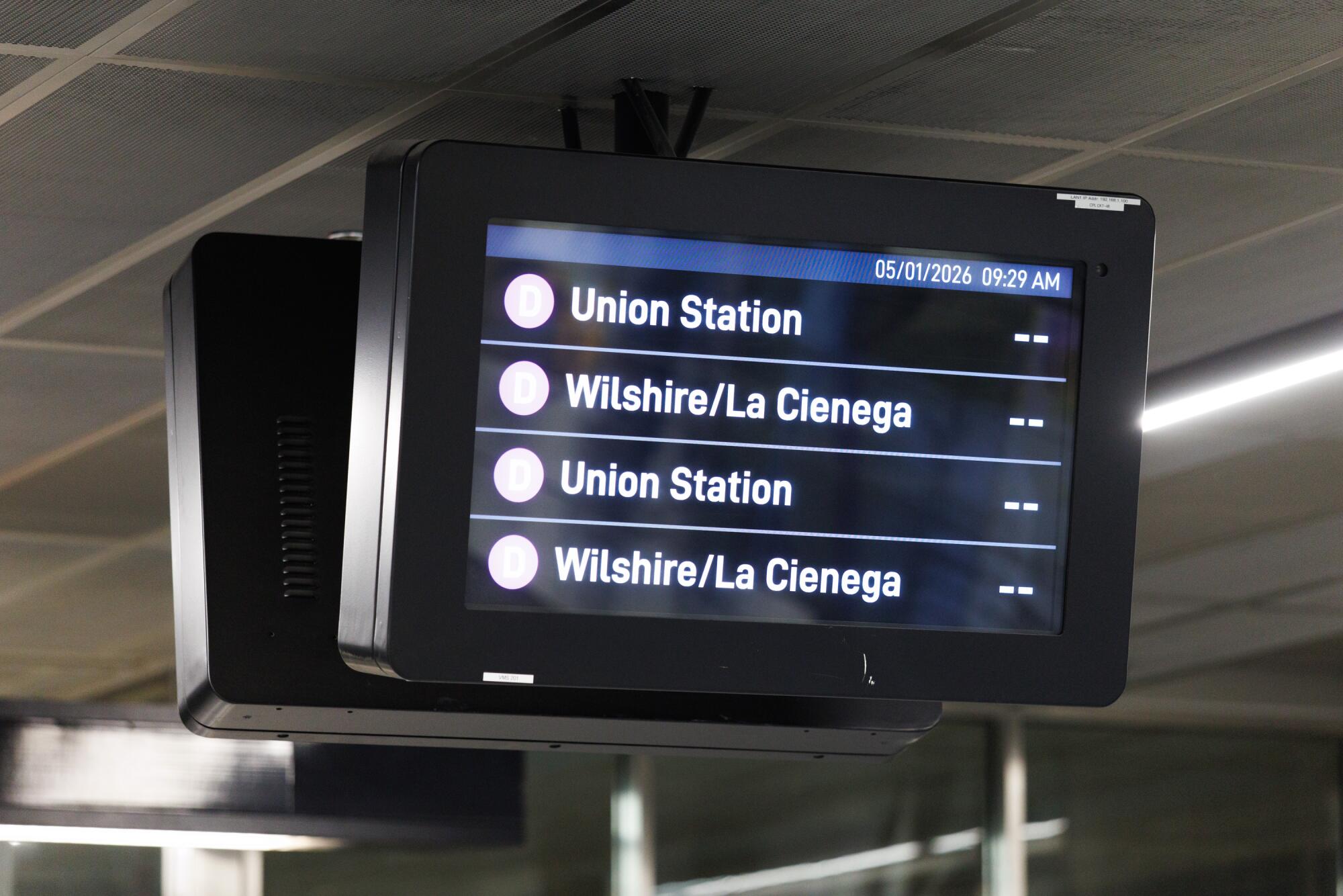 A screen mounted overhead listing Metro destinations