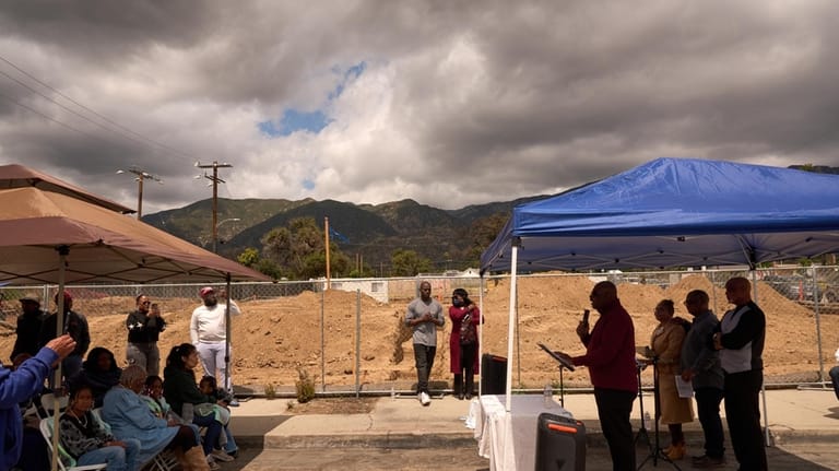 Pastor Jonathan Lewis, fourth from right, holds a groundbreaking service...